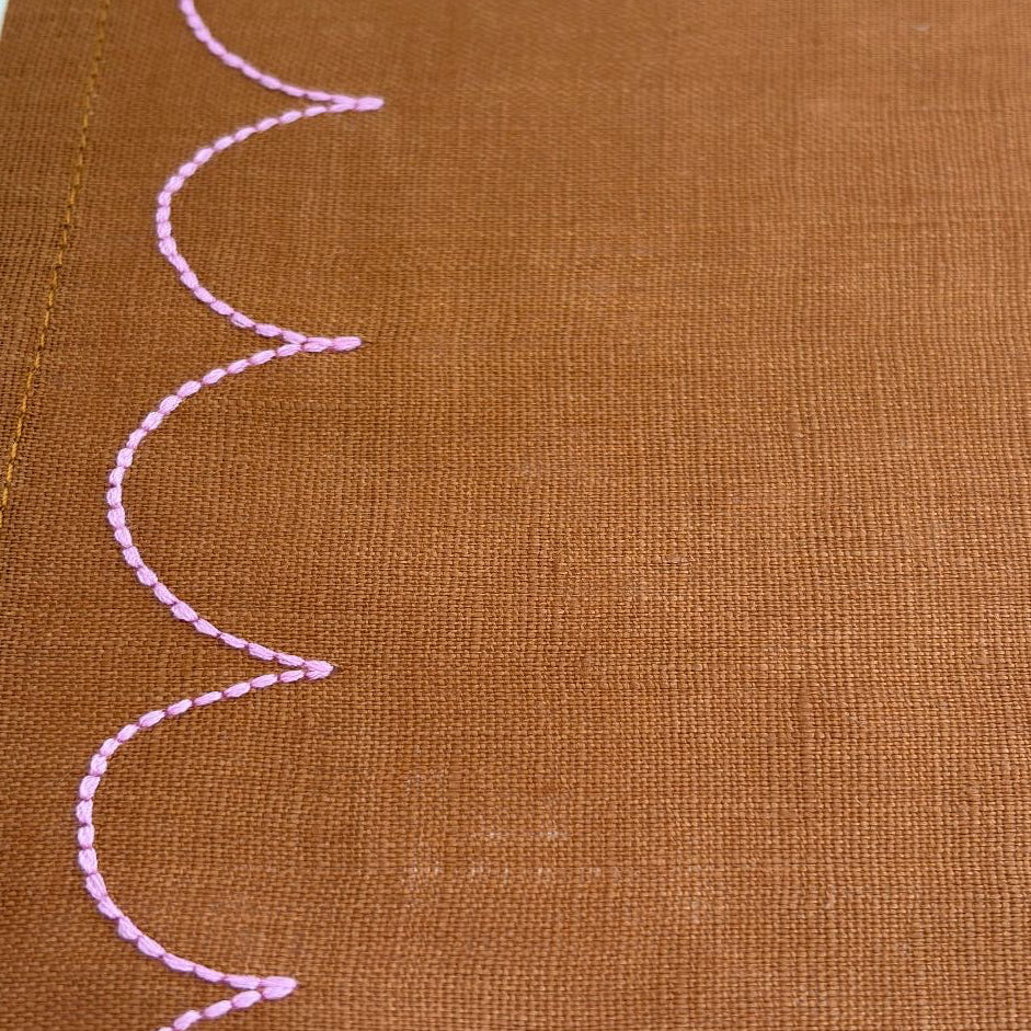 tan fabric with pink scallop embroidery stitching detail