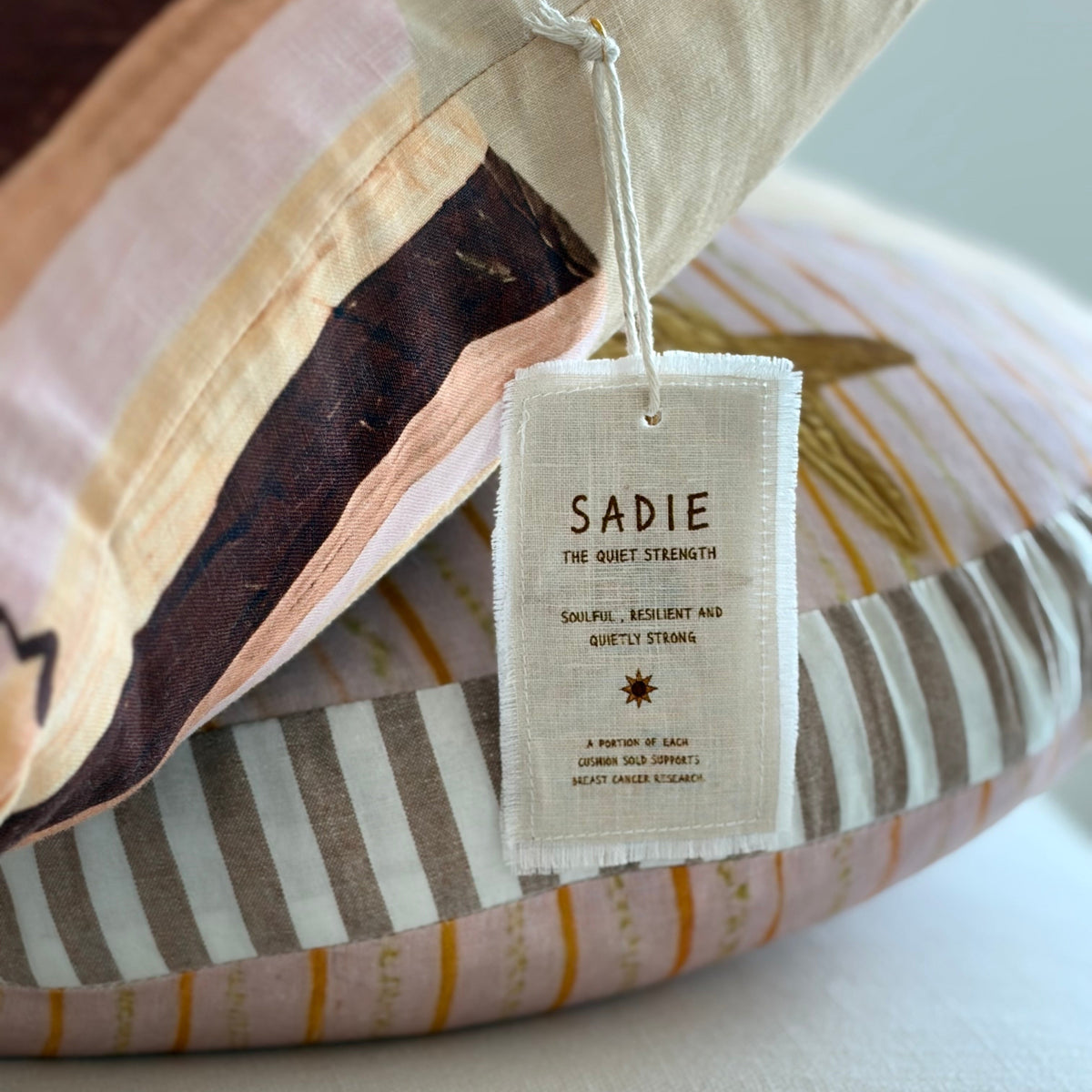 Little Nordic Sol Sadie cushion close-up showing striped edge detail and product tag