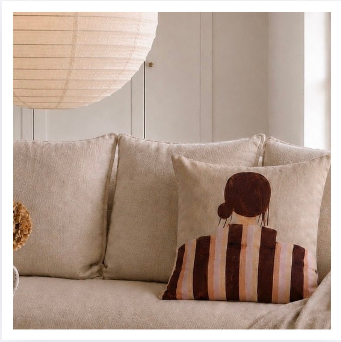 Little Nordic Sol Sadie cushion back view featuring brown and pink stripes styled on a neutral linen sofa