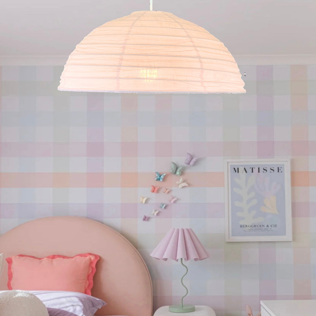 A blush pink linen light shade in a dome shape, hanging in a room with striped wallpaper and a child's room decor.