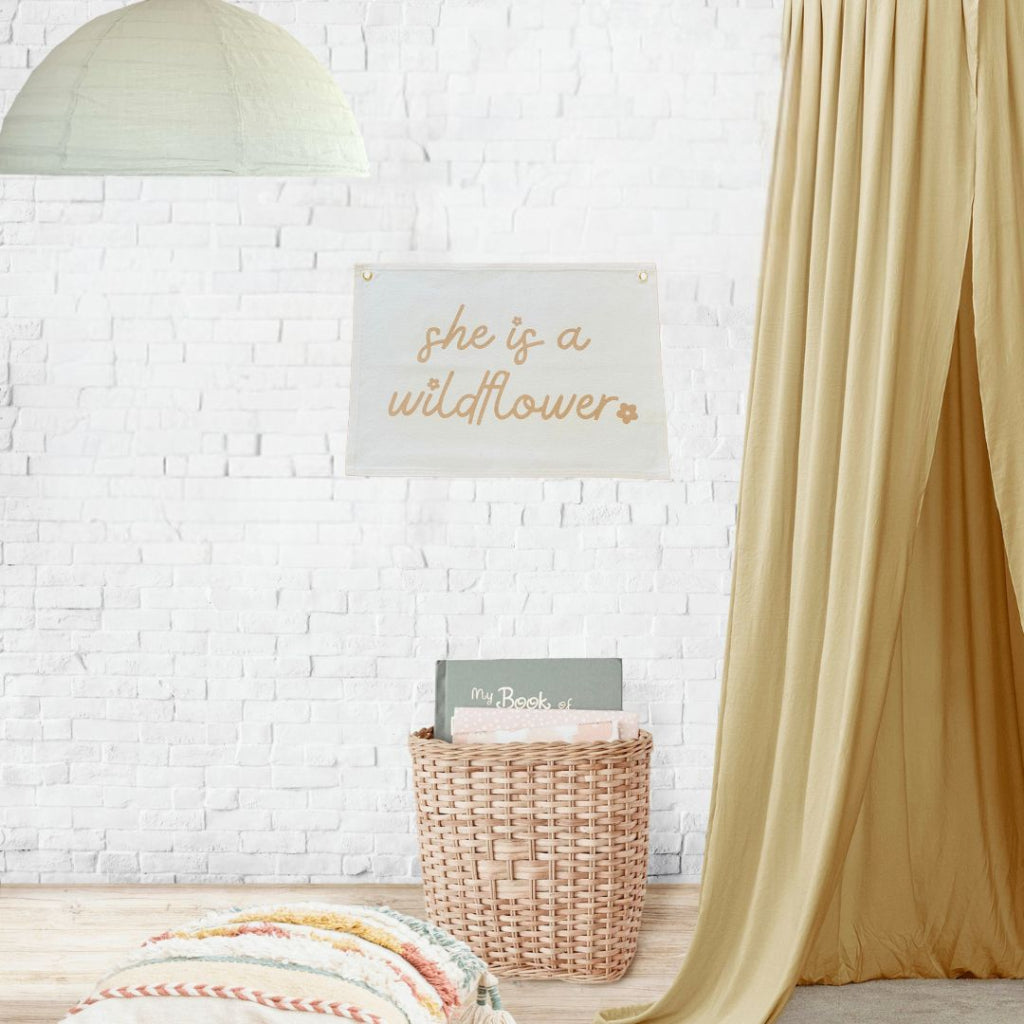 Canvas wall decor for little girls room. She is a wildflower wall hanging to decorate children's room. Printed on Canvas in bronze and pink writing.