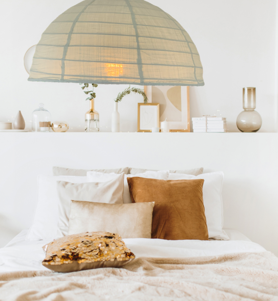 A linen light shade in a green tea colour is displayed in a bedroom setting, hanging above a bed.