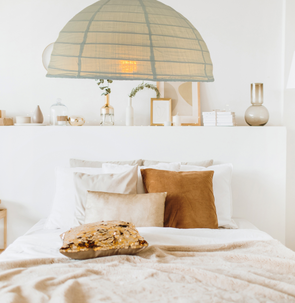 A linen light shade in a green tea colour is displayed in a bedroom setting, hanging above a bed.