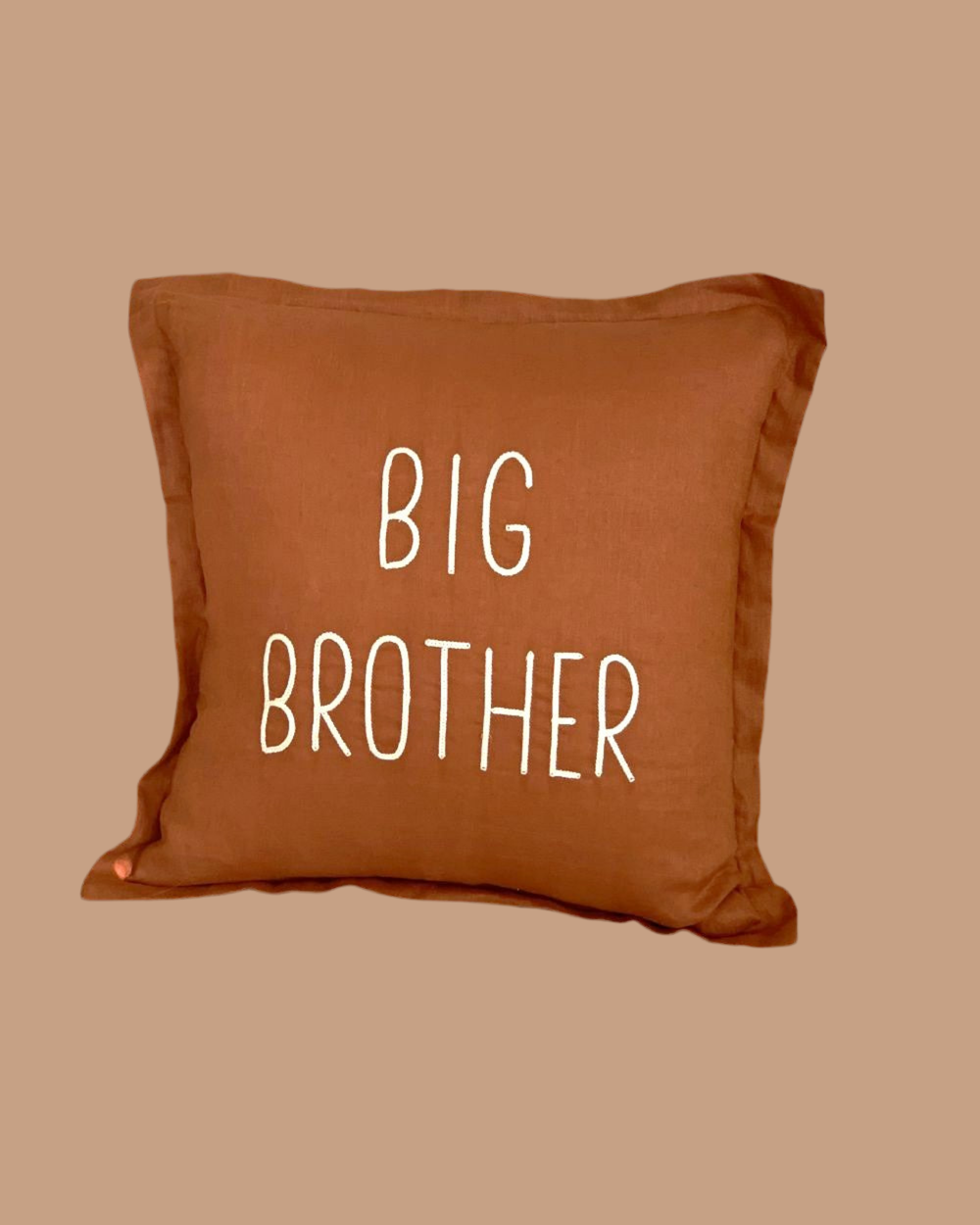Brown pillow with 'BIG BROTHER' text on a beige background