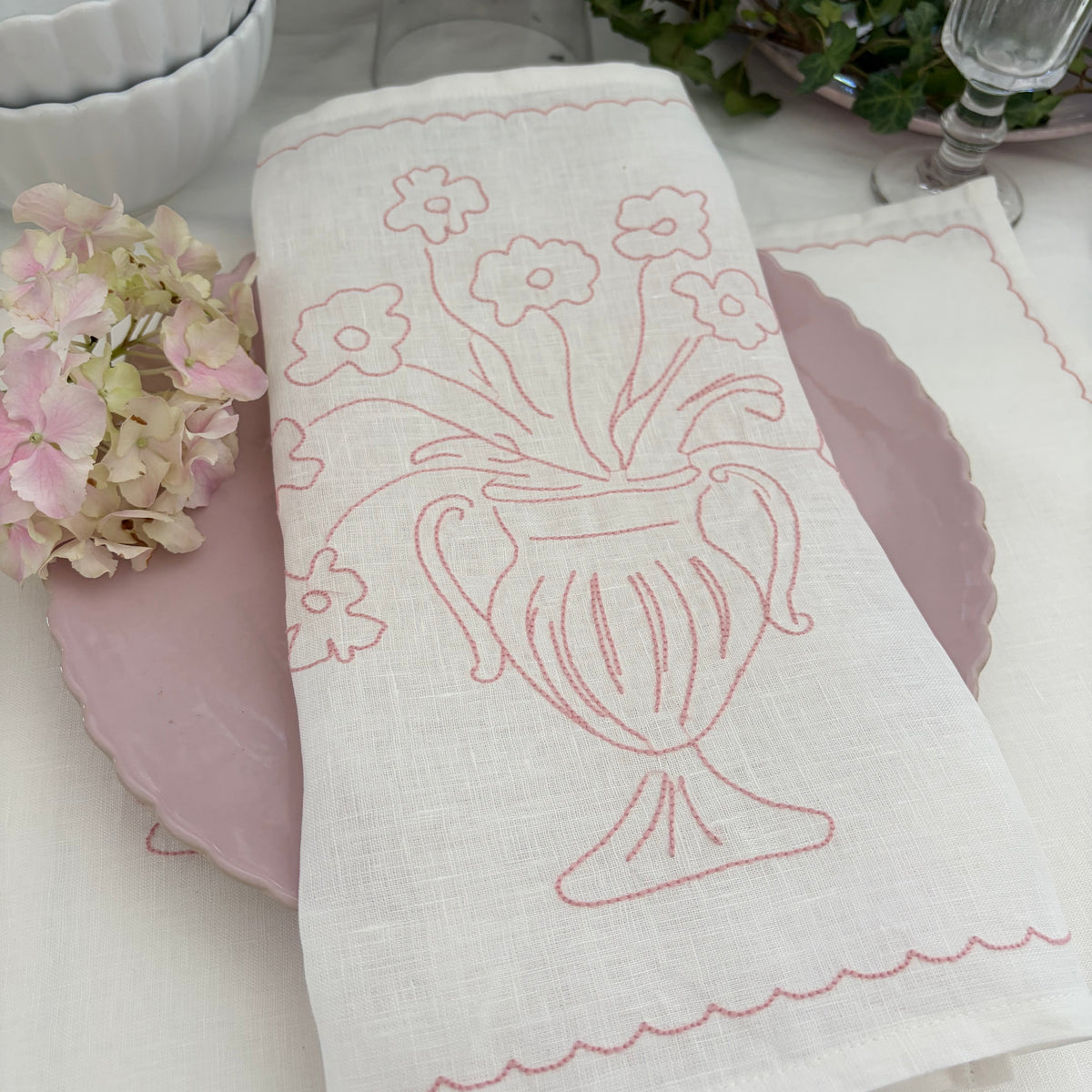 Little Nordic Sol Bloom pink linen placemat featuring an embroidered floral urn design with pink table styling.