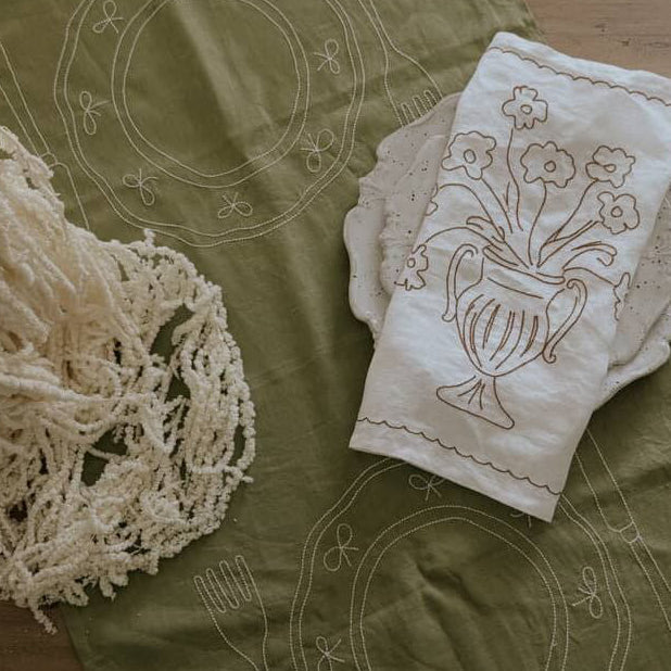 Little Nordic Sol Duo olive linen placemat styled with Bloom embroidered linen and relaxed tableware.