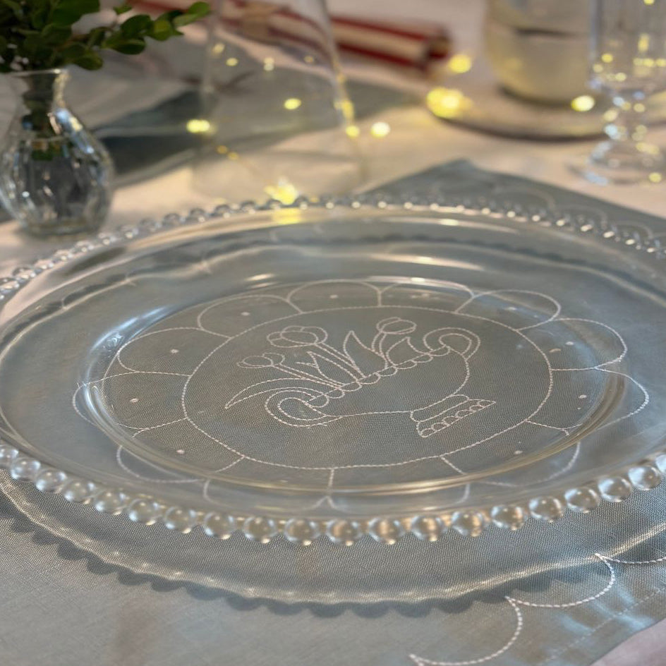 Decorative glass plate with engraved design on a table setting.