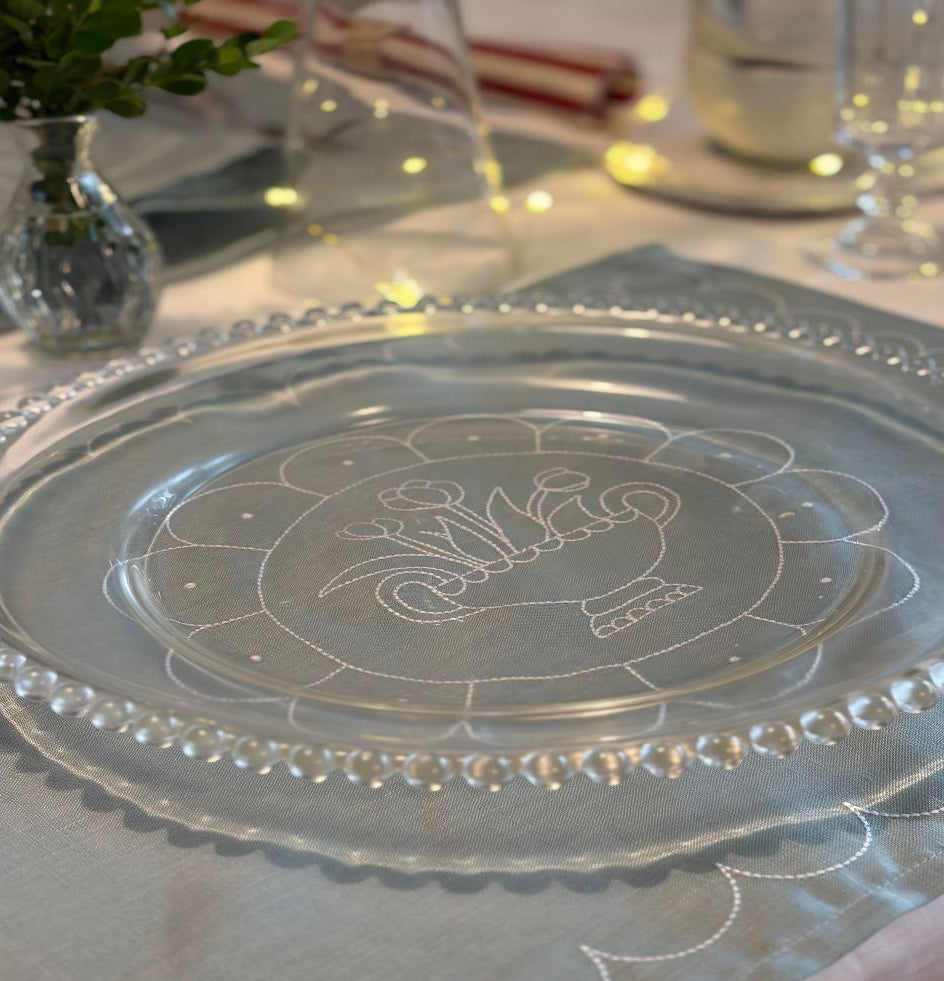 Decorative glass plate with engraved design on a table setting.