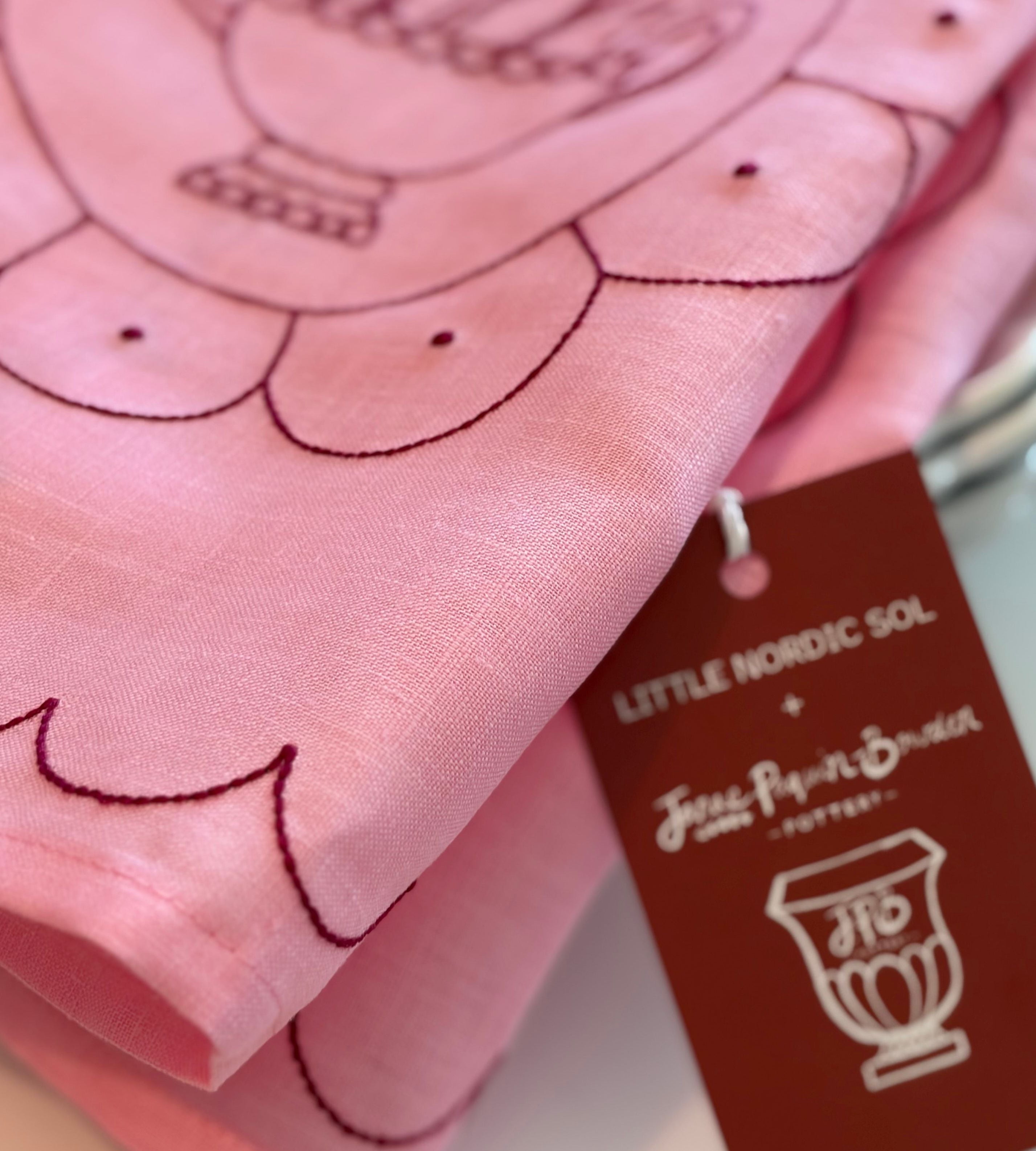 Pink fabric with embroidered design and a tag from Little Nordic Sol and Janae Paquin Bowden.