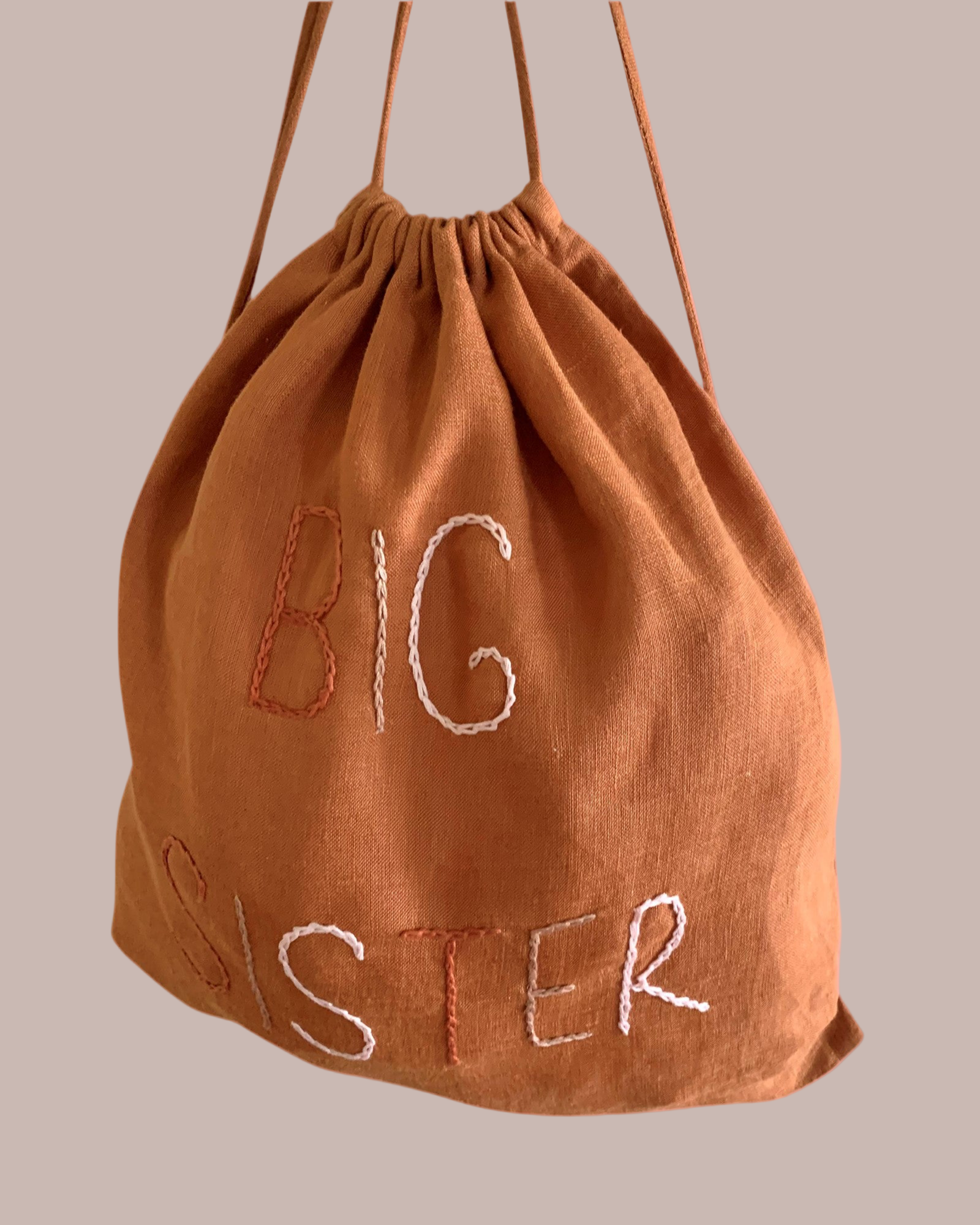 Brown drawstring bag with 'BIG SISTER' text linen lined.